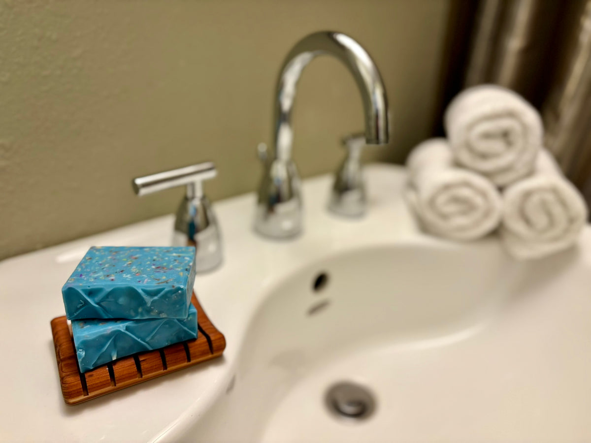 Bathroom sink with soap, towels, and faucet