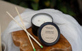 Candle with wooden match sticks on a wooden board with a white cloth background