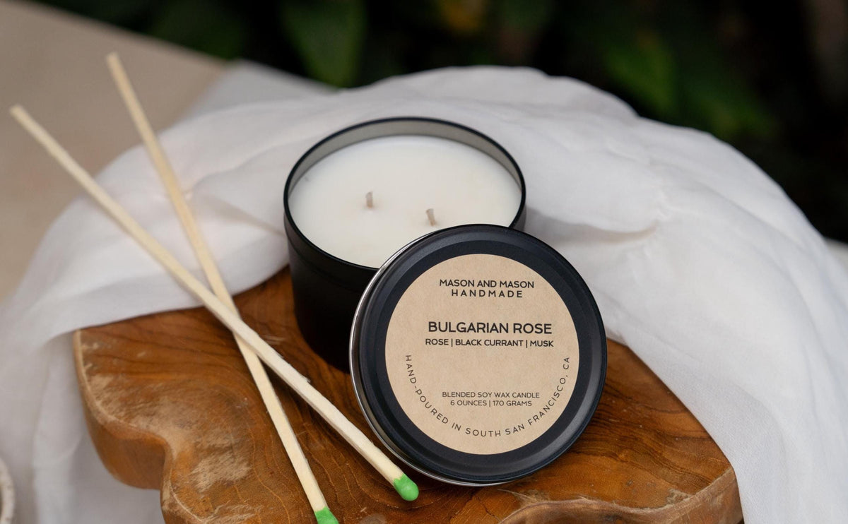 Candle with wooden match sticks on a wooden board with a white cloth background
