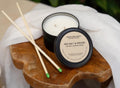 Mason and Mason handmade candle with sea salt and orchid scent on a wooden coaster with match sticks.